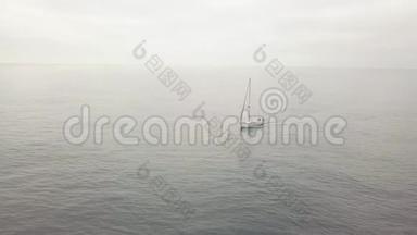 孤帆船放下帆在海上航行，背景下天空阴沉