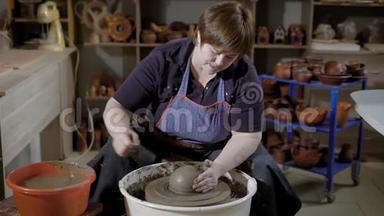 女工匠正在用陶瓷器在旋转转盘上投掷粘土坯料