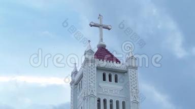 天主教十字架在天主教大教堂的顶部。 背景乌云密布的天空中有一座教堂