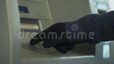 戴手套的可疑男子插入密码，从银行账户偷钱