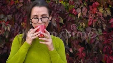 带眼镜的女人在温暖的秋日在<strong>户外喝茶</strong>或咖啡。 咖啡时间。