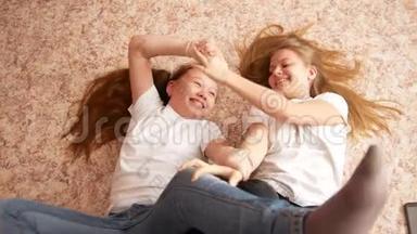 两个十几岁的<strong>女孩</strong>躺在地板上玩，玩得开心
