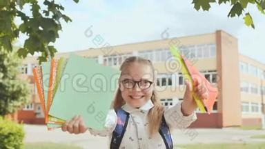 一个微笑的女学生的肖像，展示笔记本和尺子。 开学快乐..
