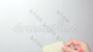 特写的女人`她的手在白板上贴着黄色的贴纸纸，上面写着10点的单词。