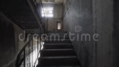 在黑暗中爬上恐怖的楼梯。 一个人在恐怖的楼梯间爬上黑暗而危险的楼梯。