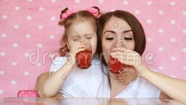 母女俩正喝着冰沙，笑眯眯的.. 年轻的女人和她的孩子一起享受一杯<strong>清爽</strong>可口的饮料。 <strong>粉色</strong>