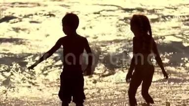 日落波浪背景下的儿童剪影。夏天的童年。儿童假日