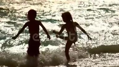 孩子们在夕阳的波浪中玩得很开心。 节日快乐。 孩子们喜欢水