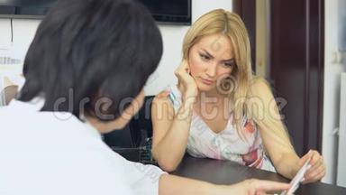 年轻的女孩在医生`预约在美容店咨询。