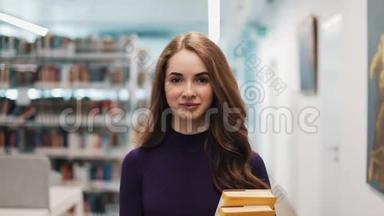 留着长发的女孩直视着摄像机，沿着图书馆的书架走着