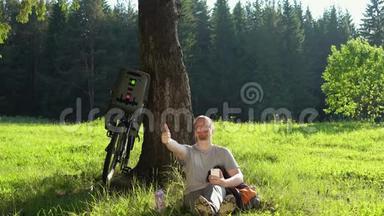 在阳光明媚的一天，男子<strong>游客</strong>骑着自行车在夏天的<strong>森林</strong>里休息。