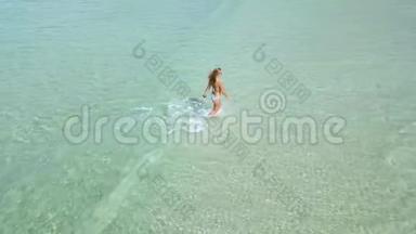 美丽的<strong>女士</strong>穿着<strong>比基尼</strong>在透明的海水中漫步夏季海滩。 绿松石海中的无人观女