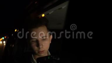 深夜在汽车后座用手机玩应用程序的青少年