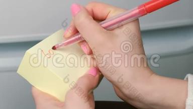 特写女人`手写在黄色的贴纸纸上，祝你好运，画心。