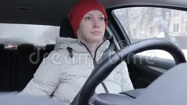 穿着<strong>冬</strong>装戴着橙色针织<strong>帽子</strong>的女人在<strong>冬</strong>道上开车