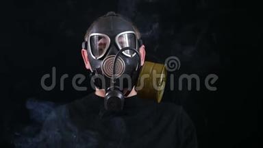 一个戴着防毒面具的人的脸在黑色的背景下可以<strong>抵御</strong>烟雾