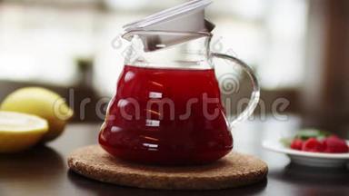 特写一个有热水和花红茶的茶壶，动作慢.. 一只手正在<strong>木器</strong>上用茶壶装饰茶