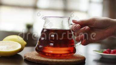 茶被倒入玻璃透明茶杯中。 一杯茶。 糖果，热茶和<strong>茶壶</strong>.. 陶瓷<strong>茶壶</strong>和玻璃茶杯