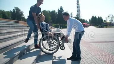 两个男人在台阶上抱着一个坐轮椅的女人。