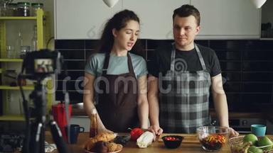 在<strong>家</strong>的厨房里，用<strong>数码</strong>相机拍摄一对迷人的情侣，录下有关烹饪美味沙拉的视频食物