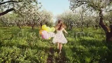 快乐的女孩带着气球在盛开的花园里奔跑