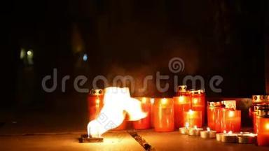燃烧的蜡烛是一个人死亡的纪念碑，火焰的火焰是红色的，广场上的一个地方，一个神奇的地方
