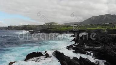 大西洋的波浪拍打着岩石海岸，顶部的景色。 海面上波涛汹涌，水溅在岸边. Tenerif