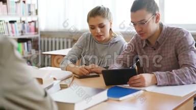 年轻的大<strong>学生们</strong>一起使用平板<strong>电脑</strong>，讨论准备考试的项目，坐在桌旁