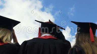 大学毕业生把学术帽子抛向蓝天，<strong>展望未来</strong>