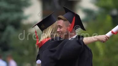 男女朋友拥抱，手里拿着高等教育文凭