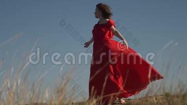 穿着猩<strong>红衣</strong>服的年轻女<strong>模特</strong>穿着风装赤脚摆姿势