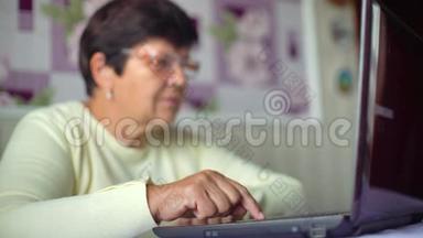 戴眼镜的老年妇女<strong>在家</strong>里用笔记本电脑<strong>上网</strong>，有免费空间和复印空间