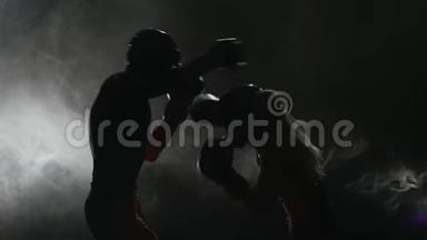 女孩在用拳击踢一个男人。 烟雾背景。 剪影。 慢动作