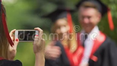 年轻一对大学<strong>毕业</strong>生拥抱和摆姿势<strong>拍照</strong>，竖起大拇指