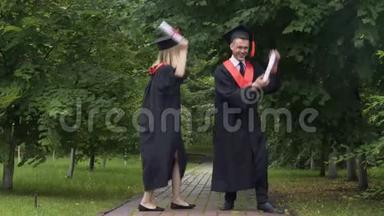 有趣的毕业生毕业后穿着学术礼服跳舞和鬼混