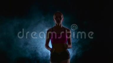 跑步<strong>运动</strong>女孩。 前景。 <strong>烟雾</strong>中的黑色屏幕。 剪影。 慢动作。 关门
