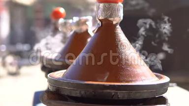 传统的摩洛哥塔吉纳食物在塔吉纳火锅里烹调，上面有烟和西红柿