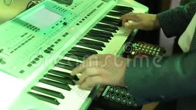 音乐家在键盘上弹奏合成器钢琴键。 音乐家在晚会上演奏乐器。 曼斯·HSNDS。