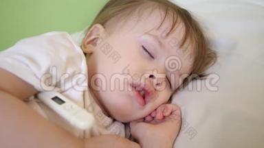 幼儿睡在医院病房的白色被褥上，用温度计<strong>测量体温</strong>.. 对儿童的治疗