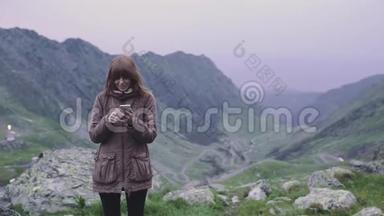 一个年轻的女人徒步旅行者爬上<strong>山脉</strong>，在智能手机相机上自拍。 罗马尼亚喀尔巴阡<strong>山脉</strong>