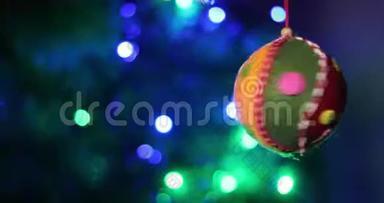 猫在云杉树枝上玩圣诞软玩具。 背景是多种颜色的圣诞<strong>彩灯</strong>花环