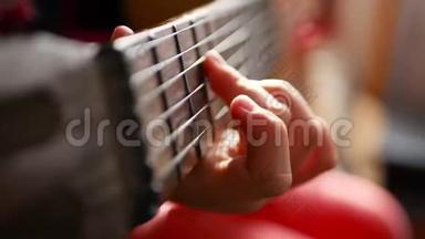 在家弹吉他的少女。 把可爱的少年关在室内，穿着一件帽衫，轻轻地弹着吉他。