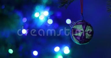 猫在云杉树枝上玩圣诞软玩具。 背景是多种颜色的圣诞彩灯花环