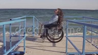 在春季或秋季，坐轮椅的残疾青年妇女在靠近海洋的斜坡旁为残疾人移动