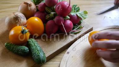 男人`手切<strong>橘红色</strong>的西红柿，夏天的健康蔬菜