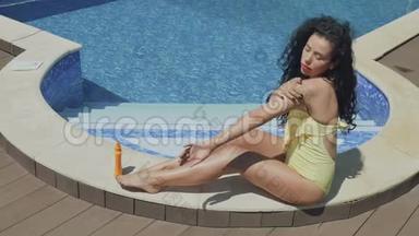 在游泳池附近，一个漂亮的卷发黑发女人用<strong>化妆水</strong>给自己抹上一层