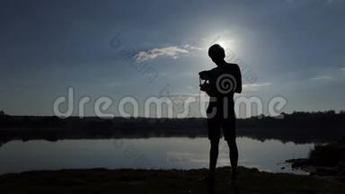 明亮的人看着他的面板，在斯洛莫的一个湖里操作一架无人机