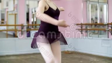 穿紫色紧身衣的年轻芭蕾舞女演员在芭蕾舞中优雅地表演某些芭蕾舞动作，以第五位的姿势表演芭蕾舞