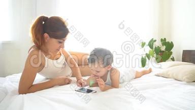 妈妈和<strong>宝宝</strong>在卧室里<strong>看</strong>智能手机