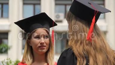 戴着学术帽的金发女人在毕业典礼上聆听最好的朋友